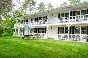 a large white house with a picnic table with an umbrella at Sea View Motel in Ogunquit