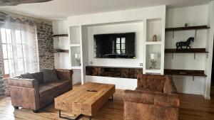 a living room with a couch and a coffee table at Escapade au cœur du Haras in Le Mesnil-Rouxelin