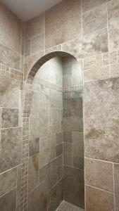 a bathroom with a shower with a stone wall at Escapade au cœur du Haras in Le Mesnil-Rouxelin +19 photos