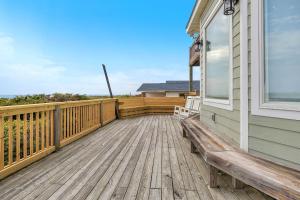a wooden deck with a bench on a house at Azohva by Oak Island Accommodations in Caswell Beach