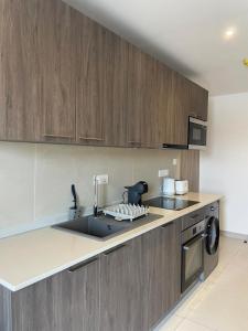 a kitchen with a sink and a stove at Delali Residence at The Bantree 5 mins from Airport in Accra