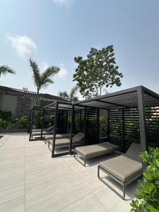 a group of benches sitting on a patio at Delali Residence at The Bantree 5 mins from Airport in Accra
