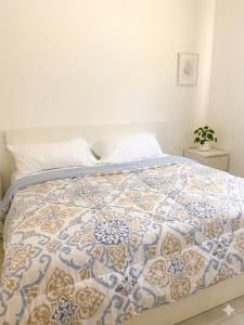 a bed with a blue and white quilt on it at Samana condo by the beach in Las Terrenas