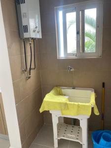 a bathroom with a sink with a yellow towel on it at Samana condo by the beach in Las Terrenas +6 photos