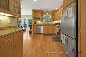 a large kitchen with wooden cabinets and stainless steel appliances at Beach Lovers Retreat in Santa Cruz