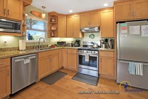 a kitchen with wooden cabinets and stainless steel appliances at Beach Lovers Retreat in Santa Cruz