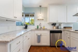 a white kitchen with white cabinets and a sink at Mitchell's Cove Beach House in Santa Cruz