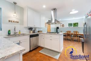 a kitchen with white cabinets and a stainless steel refrigerator at Mitchell's Cove Beach House in Santa Cruz +19 photos