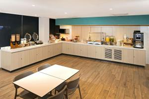 a large kitchen with a table and chairs in it at City Express by Marriott Nuevo Laredo in Nuevo Laredo