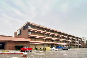 a large building with cars parked in a parking lot at Airport Inn Memphis Near Graceland By Hotel O in Memphis
