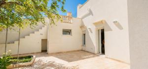 a white house with stairs and a courtyard at Domus Avi - Bed and Breakfast in Taviano