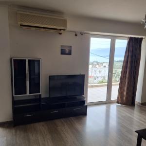 a living room with a flat screen tv and a large window at Sea View apartment in Gythio
