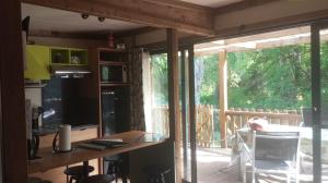 a kitchen with a sliding glass door to a deck at chalet in Onesse-et-Laharie