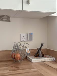 a room with a book and a basket on the floor at The Calm Space Room in Balderton