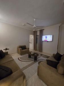 a living room with two couches and a flat screen tv at النزهه in Quseir