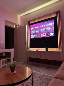 a living room with a large flat screen tv at Downtown Deluxe Apartment in Shkodër