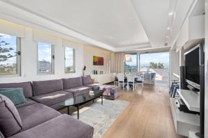 a living room with a couch and a tv at City Penthouse in Larnaca