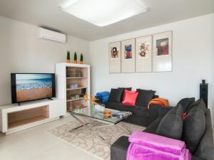 a living room with a couch and a tv at Bungalow San Agustin Rocas Rojas in San Agustin