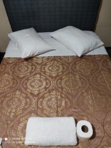 a bed with two pillows and two towels on it at Mihostal Bless in Tacna