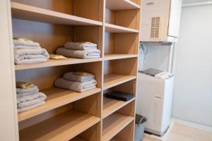 a closet with wooden shelves and towels at YMA House in Nago +61 photos