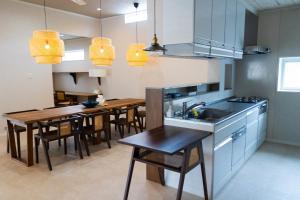 a kitchen with a table and a dining room at YMA House in Nago