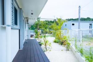 a balcony of a house with a wooden deck at YMA House in Nago