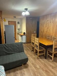 a living room with a table and chairs and a kitchen at Cabañas rio fuy Tinaja in Puyehue