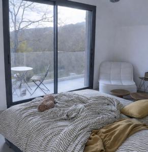 a bed in a bedroom with a large window at STUNNING VIEW, chambre en forêt proche BORDEAUX in Bouliac +15 photos