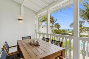 a table and chairs on a balcony with a view of the ocean at Alamanda 114 Oceanview 2BR Steps from Orient Bay in Orient Bay