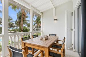 a dining room with a wooden table and chairs at Alamanda 114 Oceanview 2BR Steps from Orient Bay in Orient Bay