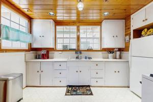 eine Küche mit weißen Schränken und einer Holzdecke in der Unterkunft Crestline Charm in Crestline
