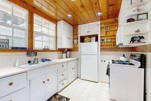 eine Küche mit weißen Geräten und Holzdecken in der Unterkunft Crestline Charm in Crestline + 15 Fotos