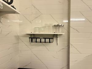 a shelf in a bathroom with glasses on it at Nova Residences Viman Studios in Pune +57 photos