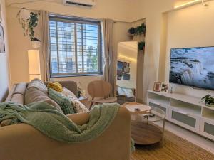 a living room with a couch and a flat screen tv at Nova Residences Viman Studios in Pune