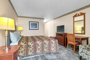 a hotel room with a bed and a desk at Airport Inn Memphis Near Graceland By Hotel O in Memphis