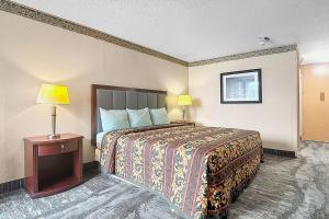 a hotel room with a bed and two lamps at Airport Inn Memphis Near Graceland By Hotel O in Memphis