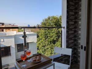 a table with two glasses of wine on a balcony at Nova Residences Viman Studios in Pune