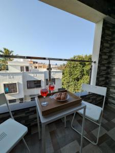 a table with two glasses of wine on a balcony at Nova Residences Viman Studios in Pune