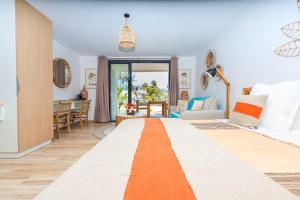 a room with a bed with an orange stripe at Studio 6 Alamanda Resort Orient Bay in Orient Bay +22 photos
