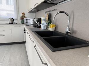 a kitchen with a black sink in a kitchen at A102 La Filanda by Larihome in Pianello Del Lario +7 photos