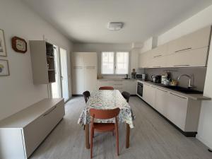 a kitchen with a table and chairs and a kitchen with white cabinets at A102 La Filanda by Larihome in Pianello Del Lario