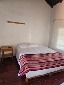 a bedroom with a bed with a blanket on it at Real Casona Chacas in Chacas