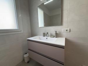 a white bathroom with a sink and a mirror at A102 La Filanda by Larihome in Pianello Del Lario