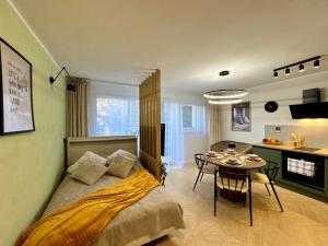 a bedroom with a bed and a table and a kitchen at Studio Jurasz I in Bydgoszcz