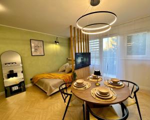 a living room with a table and a bed at Studio Jurasz I in Bydgoszcz
