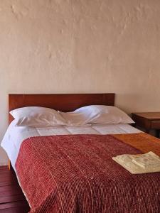 a bedroom with a bed with a red and white blanket at Real Casona Chacas in Chacas