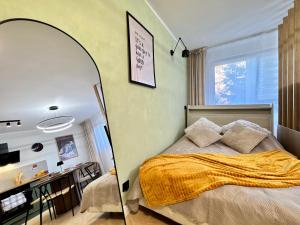 a bedroom with a bed with a large oval mirror at Studio Jurasz I in Bydgoszcz +2 photos