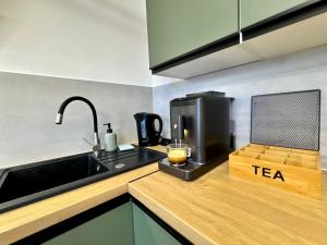 a kitchen with a sink and a coffee maker on a counter at Studio Jurasz I in Bydgoszcz