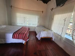 a bedroom with two beds and a window at Real Casona Chacas in Chacas