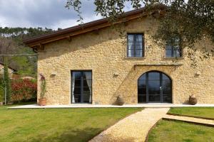 a large stone house with a grass yard at Casa Gabri Boutique B&B Tuscan Villa retreat in Massa